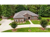 Beautiful brick home with well-manicured lawn, curved driveway, and lovely landscaping at 106 Pier Point Dr, Stony Point, NC 28678