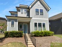 Charming two-story home with blue door, inviting front porch and manicured landscaping at 11211 James Coy Rd, Huntersville, NC 28078