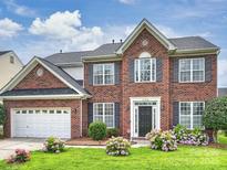 Charming two-story brick home with landscaped front yard and attached two-car garage at 11332 Anna Rose Rd, Charlotte, NC 28273