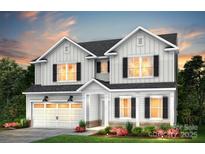 Charming two-story home with white siding, black shutters, a two-car garage, and a beautifully landscaped front yard at 12235 Colton View Ln # 386, Charlotte, NC 28278