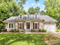 Charming one-story home boasts beautiful landscaping, dormer windows, and an attached two car garage at 13600 Seastone Ln, Pineville, NC 28134