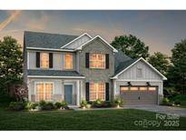 New two-story home featuring a stone and vinyl facade, a two-car garage, and a well-manicured lawn at 13908 Penbury Rd # 394, Charlotte, NC 28278