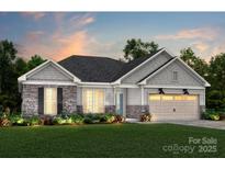 Charming single-story home with stone accents, a two-car garage, and a well-manicured lawn at 13912 Penbury Rd # 395, Charlotte, NC 28278