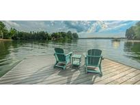 Inviting dock with two Adirondack chairs overlooking the serene lake, perfect for relaxing at 18205 Royal Oak Rd, Charlotte, NC 28278
