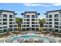 Stunning view of a modern condo complex with a sparkling pool and lush greenery at 19329 Watermark Dr # 422, Cornelius, NC 28031