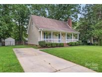 Charming single-story home with a welcoming front porch and beautifully manicured lawn at 6706 Farrington Ln, Charlotte, NC 28227