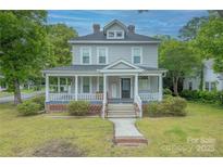 Charming two-story home featuring a welcoming front porch with classic columns and landscaped front yard at 119 Foote St, Chester, SC 29706