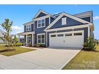 Charming two-story home with a two-car garage, manicured lawn, and beautiful curb appeal at 12205 Hollinhope Dr, Charlotte, NC 28278