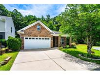 Charming brick home with a two-car garage, manicured lawn, and beautiful landscaping for great curb appeal at 141 Aberdeen Dr, Troutman, NC 28166