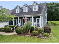Charming home featuring a welcoming front porch, dormer windows, and beautifully landscaped front yard at 162 Castles Gate Dr, Mooresville, NC 28117