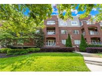 Beautiful brick condo building featuring manicured lawn, mature landscaping, and private balconies at 1903 Kenilworth Ave # 104A, Charlotte, NC 28203