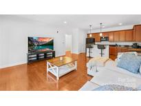 Inviting living room featuring hardwood floors and an open layout to the kitchen and bar seating at 1903 Kenilworth Ave # 104A, Charlotte, NC 28203