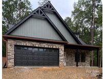 Beautiful new home features stone and siding, with a two-car garage and covered porch at 1923 Fairfield Rd, Mount Gilead, NC 27306