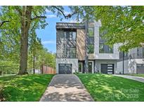 Contemporary two-story home with a gray and white exterior, attached garages, and manicured lawn at 209 Keswick Ave, Charlotte, NC 28206