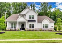 Charming two-story home featuring a manicured lawn, stone accents, and welcoming front porch at 2324 Loire Valley Dr, Indian Land, SC 29707
