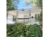 Inviting front porch featuring a decorative railing and white siding, complemented by lush greenery at 237 Institute St, Mooresville, NC 28115