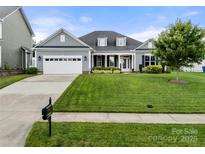 Charming single-Gathering home featuring a well-manicured lawn and an attached two-car garage at 2399 Ashbourne Se Pl, Concord, NC 28025