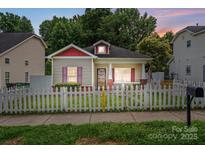 Charming single-story home with white picket fence, red trim, and cozy curb appeal at 2723 Craddock Ave, Charlotte, NC 28208