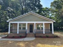 Charming single story home features a welcoming front porch and well-manicured landscaping at 307 Wilson St, Monroe, NC 28112