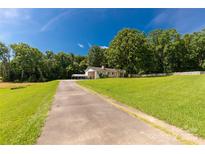 Sprawling property featuring a charming home, lush lawn, mature trees, and long driveway at 4330 Rowell Rd, Lancaster, SC 29720
