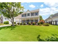 Charming two-story home with a spacious front yard, welcoming porch, and classic architectural details at 4469 Greystone Sw Dr, Concord, NC 28027