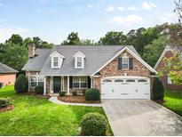 Charming brick home with well-manicured lawn, dormer windows, and a two-car garage at 5707 Sustar Dr, Monroe, NC 28110