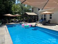 Backyard pool with lounge seating, umbrellas, cabana, and inflatable toys for the whole Gathering to enjoy on a hot summer day at 7700 Antique Cir, Waxhaw, NC 28173