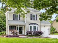 Charming two-story home with black shutters, manicured lawn, and an attached single-car garage at 9908 Park Springs Ct, Charlotte, NC 28210