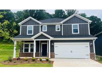 Two-story home with gray siding, white trim, a two-car garage, and a well-manicured lawn at 145 Satchel Ct, Mooresville, NC 28115