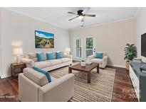 Bright living room with wood floors, ceiling fan, and access to a balcony or patio at 17136 Red Feather Dr, Charlotte, NC 28277