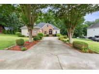 Charming brick home featuring a spacious driveway and a well-manicured front yard with beautiful, mature trees at 172 Hunters Hill Dr, Statesville, NC 28677