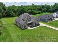 Gorgeous gray home with a large lawn and a covered front porch perfect for relaxing at 174 Bellingshire Dr, Mt Ulla, NC 28125