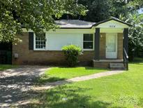 Charming single-story home with a brick facade, well-maintained lawn, and inviting front entrance at 1824 Maribel Ave, Charlotte, NC 28216