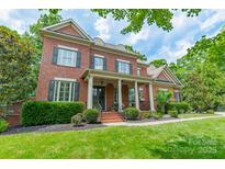 Charming two-story brick home with a welcoming front porch and manicured lawn at 2004 Viscount Dr, Matthews, NC 28104