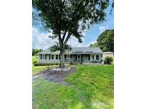 Charming ranch-style home with a large front yard and mature tree providing shade at 24007 Old Aquadale Rd, Albemarle, NC 28001