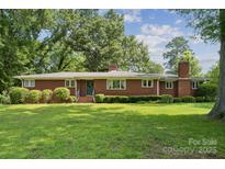 Charming one-story brick home with manicured lawn and mature trees, providing a serene curb appeal at 2500 Kendrick Dr, Charlotte, NC 28214