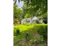 Charming cottage-style home with a well-maintained lawn and mature trees providing ample shade and privacy at 3275 Love Rd, Claremont, NC 28610
