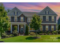 Charming two-story home boasting a landscaped yard, stone accents, and welcoming front porch at 4386 Oldstone Dr, Harrisburg, NC 28075