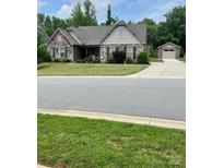 Charming single-Gathering home with stone accents, a manicured lawn, and a detached two-car garage at 5332 Pembrey Dr, Denver, NC 28037