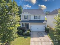 Charming two-story home with a well-maintained lawn and a two car garage at 6945 Agava Ln, Charlotte, NC 28215