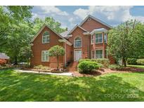Beautiful brick home with manicured lawn, mature trees, and inviting front entrance at 7301 Leharne Dr, Charlotte, NC 28270