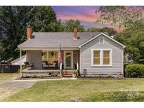 Charming single-story home with a cozy front porch, swing and well-manicured landscaping at 810 Maplewood Ave, Kannapolis, NC 28081