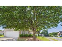 Charming home with a well-manicured front yard and beautiful, mature tree providing plenty of shade on a sunny day at 9030 Gander Dr, Charlotte, NC 28277