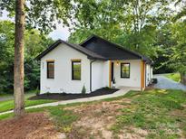 Charming single-story home with a white brick exterior, black accents, and professional landscaping at 922 Maurice St, Monroe, NC 28112