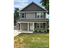 Charming two-story home with gray siding, dark shutters, front porch, and landscaped front yard at 1017 W C St, Kannapolis, NC 28081