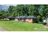 Charming brick home featuring a well-manicured lawn and inviting front porch at 135 Burton Hills Cir, Gastonia, NC 28054