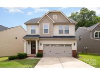 Charming two-story home features a two-car garage, neat landscaping, and a welcoming front entrance at 1825 Evergreen Dr, Charlotte, NC 28208