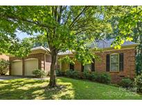 Charming brick home featuring a well-manicured lawn and a two-car attached garage at 212 Foxfield Ln, Matthews, NC 28105