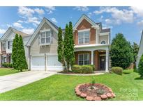 Charming two-story home with a well-manicured lawn and attractive landscaping on a sunny day at 2240 Arbor Vista Dr, Charlotte, NC 28262