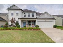 Charming two-story home with a manicured lawn, a blue front door, and an attached two-car garage at 3009 Palm Dr, Fort Mill, SC 29715